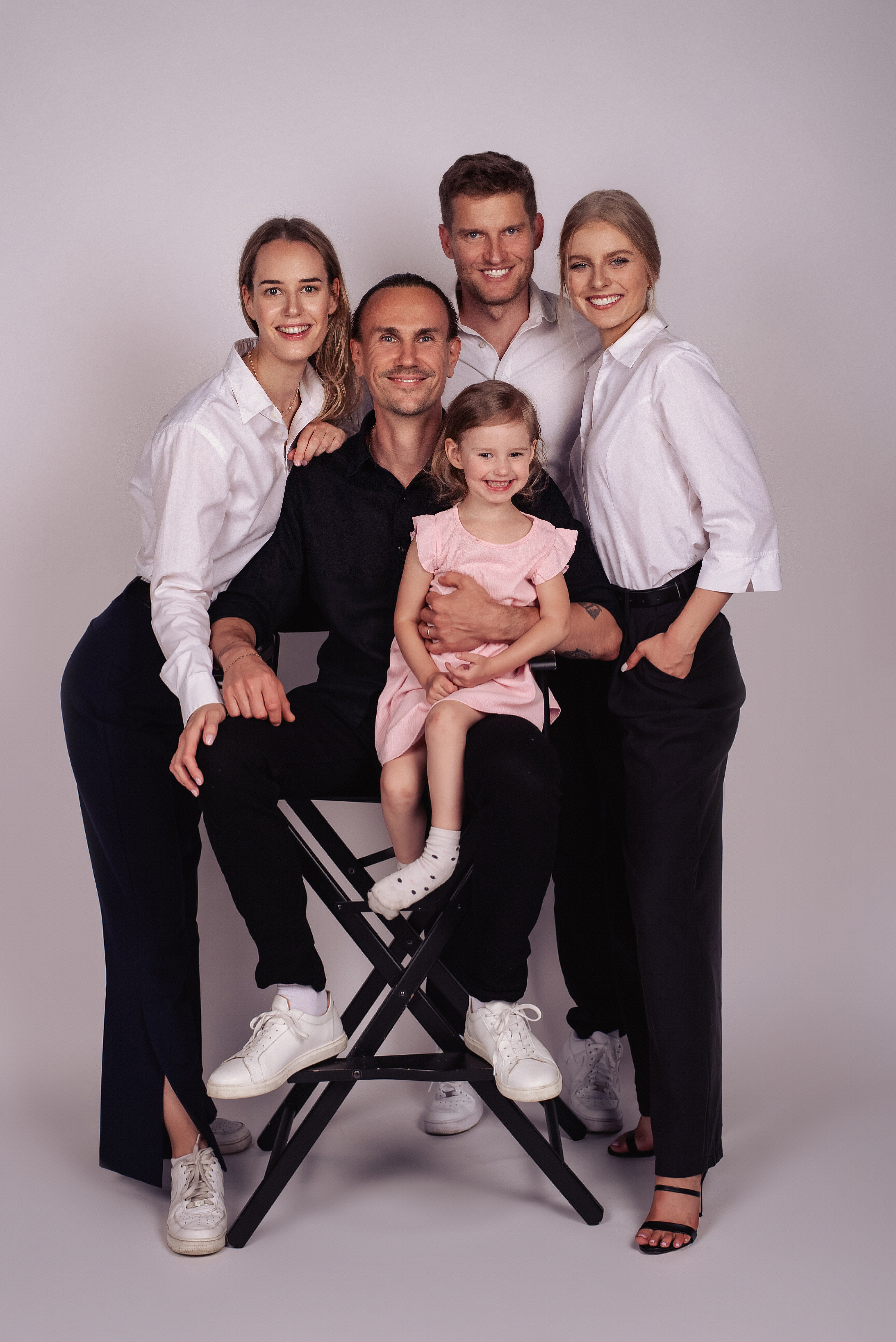 The Urban Wolf team behind SOHO Suites Old Town. Michael Urban with daughter on his lap, flanked by designers Aneža Oboda, Michal Wolf and hospitality manager Ieva Glaveckaite. Photographed in a Prague studio.